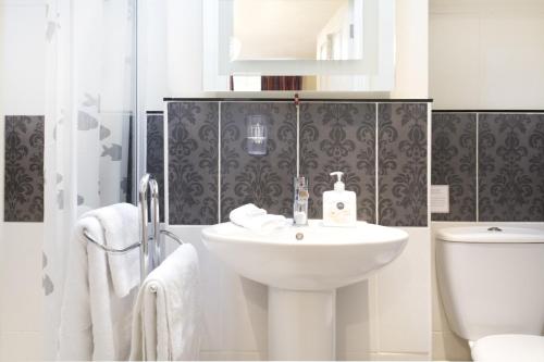 a white bathroom with a sink and a toilet at Number14brighton in Brighton & Hove