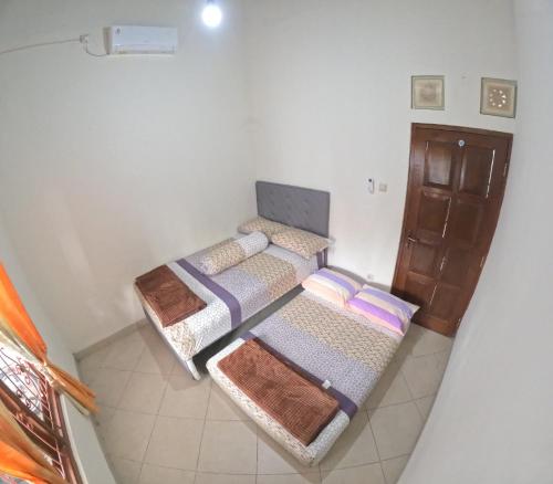 um quarto com duas camas e um armário em JE Homestay Jogja em Sentool