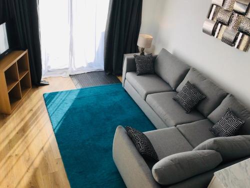 a living room with a couch and a blue rug at Arma Short Stays 46 Bicester - Sleeps 3 - Free Parking & Garden in Bicester