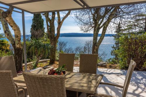 Una mesa y sillas en un patio con vista al agua. en Holiday home Viktorija, en Dramalj