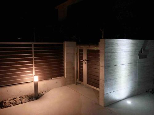 a wooden fence with a gate and a light on it at night at 雅 芦ノ湖 別荘 箱根 Miyabi Ashinoko villa hakone in Sekishoato