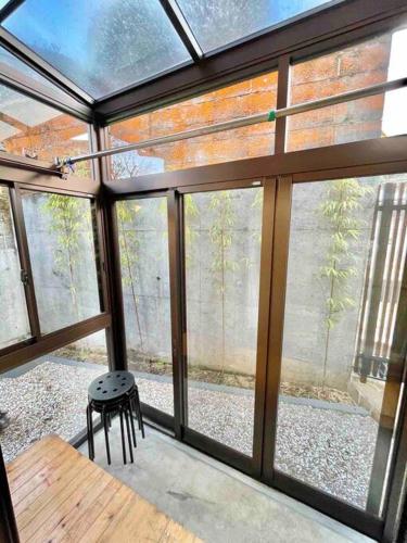 a room with glass windows and a table and a stool at 雅 芦ノ湖 別荘 箱根 Miyabi Ashinoko villa hakone in Sekishoato