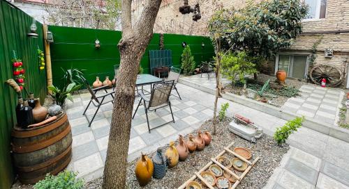 a patio with a table and chairs and a tree at Book Hotel in Tbilisi City