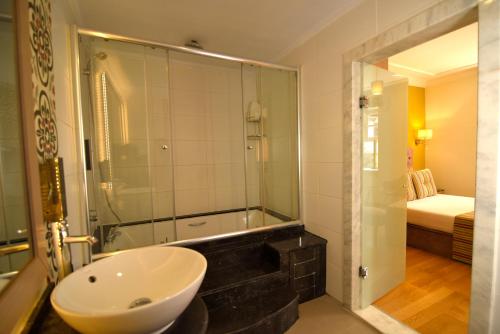 a bathroom with a sink and a shower and a tub at Comfortable Flat with Jacuzzi near Hadrian's Gate in Antalya