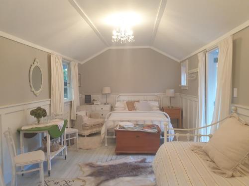 una camera con due letti, un divano e un tavolo di Cabins on Tudor bed & breakfast a Motueka