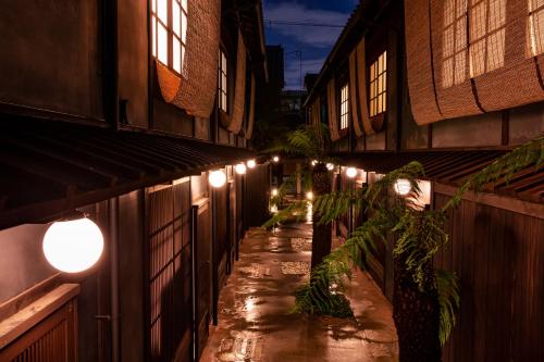 un callejón con luces en el lateral de un edificio en Rinn Shiki Juraku en Kioto
