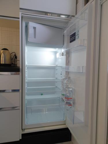 un frigorifero vuoto con la porta aperta in una cucina di Casetta Donatello a Marina di Pietrasanta