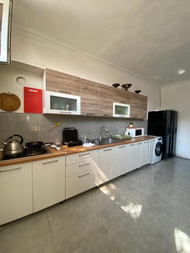 a kitchen with white cabinets and a black refrigerator at CHEMPION HOSTEL BAKU in Baku