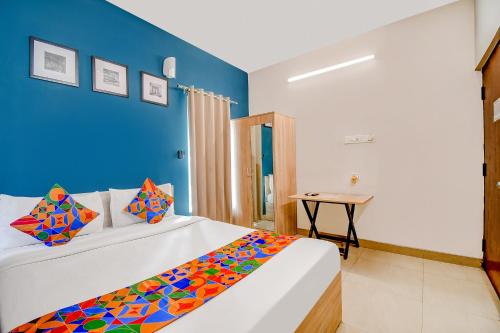 1 dormitorio con 1 cama con pared azul en FabHotel Silverkey, en Calcuta