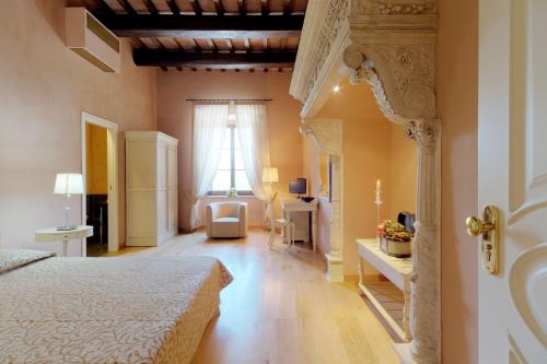 a bedroom with a bed and a chair in a room at Castello di Baccaresca in Branca