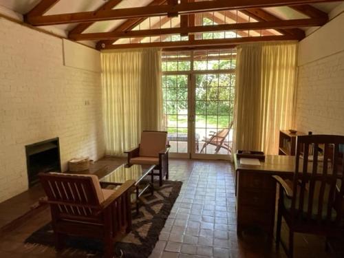 a living room with a table and chairs and a fireplace at Weaver Cottages in Harare