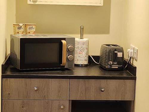 a microwave and a toaster oven sitting on a counter at taigh beag in Fort William