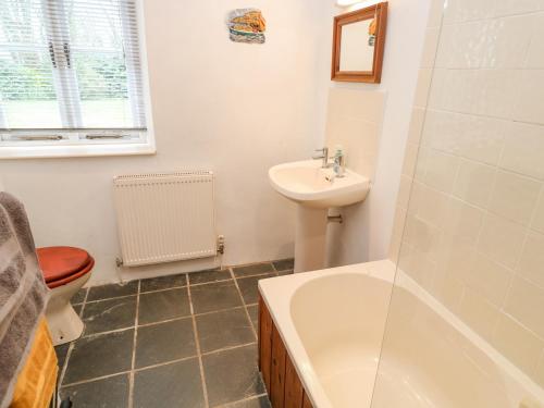 a bathroom with a sink and a tub and a toilet at Swallows in Saint Keverne