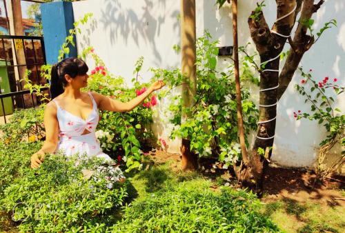 a woman in a dress standing in a garden at Casa Brooklyn Portuguese Heritage in Saligao