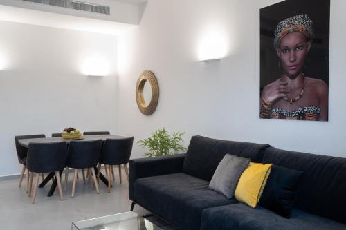 a living room with a blue couch and a table at Shikma Ella Sun in Eilat