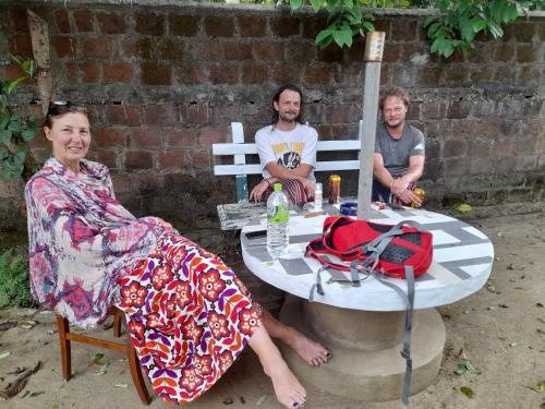 eine Gruppe von drei Personen, die um einen Tisch sitzen in der Unterkunft Devi Tourist Home in Polonnaruwa