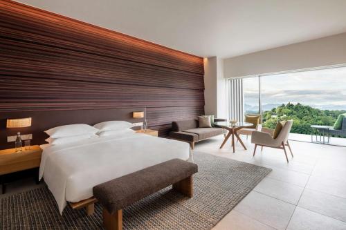 een slaapkamer met een groot bed en een groot raam bij Hyatt Centric Kota Kinabalu in Kota Kinabalu