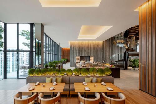 ein Restaurant mit Tischen und Stühlen und eine Lobby in der Unterkunft Hyatt Centric Kota Kinabalu in Kota Kinabalu