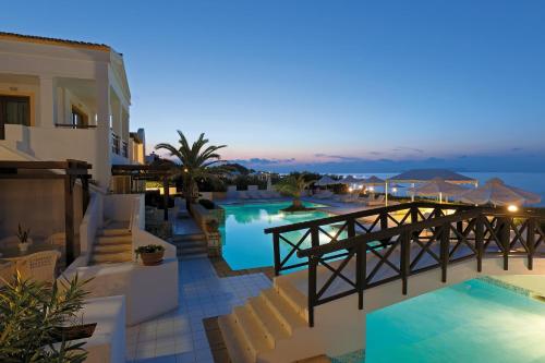 a view of a resort with a pool at night at Aldemar Knossos Villas in Hersonissos