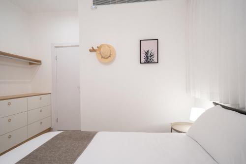a white bedroom with a bed and a closet at Shikma Ella Sun in Eilat