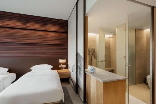 a bedroom with a bed and a walk in shower at Hyatt Centric Kota Kinabalu in Kota Kinabalu