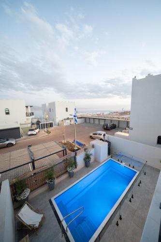 a swimming pool on the roof of a building at Shikma Ella Sun in Eilat