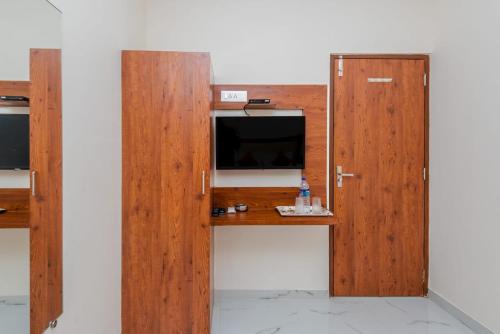 a wooden door with a television in a room at Hotel Purple Orchid in Mumbai