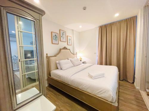 1 dormitorio con cama y ventana grande en Summer Huahin311, 150m from beach. Near Cicada and Tamarind., en Hua Hin