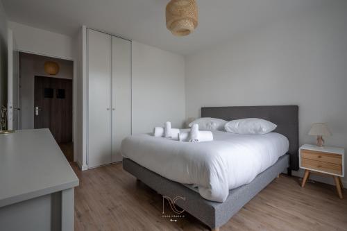 une chambre avec un grand lit avec des draps et des oreillers blancs dans l'établissement Disneyland-Paris 4pers, Parking, Wifi, à Serris