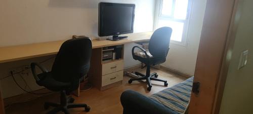 an office with two chairs and a desk with a television at apart paz in Torrevieja
