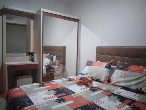 a bedroom with a bed and a mirror at Tifolia Apartment Pulomas - Kelapa Gading in Jakarta