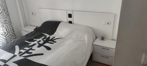 a bedroom with a bed with a black and white comforter at apart paz in Torrevieja