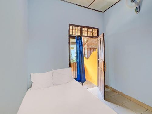 sypialnia z białym łóżkiem i otwartymi drzwiami w obiekcie SPOT ON 92404 Pondok Ai w mieście Cupel