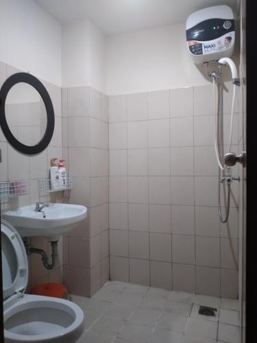 a bathroom with a shower and a toilet and a sink at Tifolia Apartment Pulomas - Kelapa Gading in Jakarta