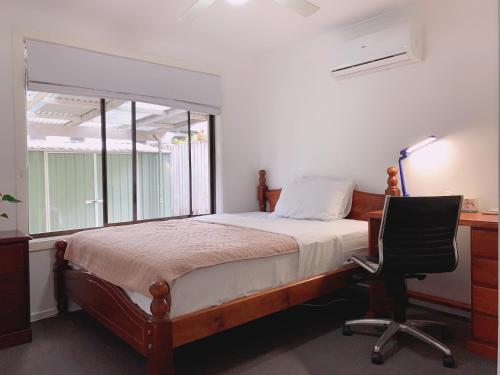 a bedroom with a bed and a desk and a chair at Home Away From Home-(Room1) in Gold Coast