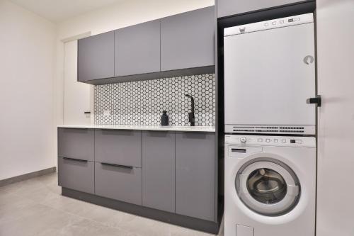 a kitchen with a washer and a washing machine at Indulge Apartments - City View Penthouses in Mildura