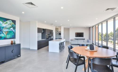 an open kitchen and dining room with a table and chairs at Indulge Apartments - City View Penthouses in Mildura
