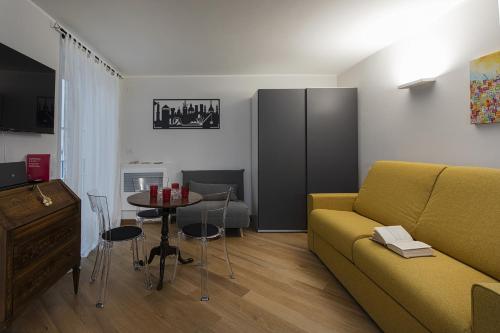 uma sala de estar com um sofá amarelo e uma mesa em Superba Studio by Wonderful Italy em Gênova