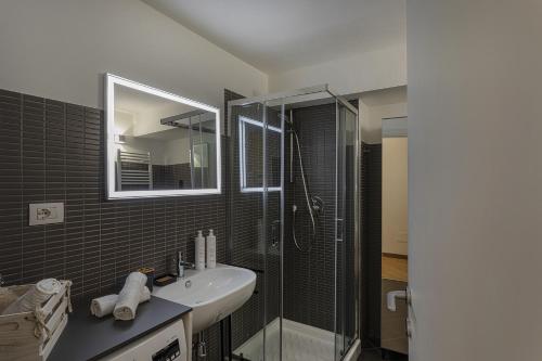 uma casa de banho com um lavatório e um chuveiro com um espelho. em Superba Studio by Wonderful Italy em Gênova