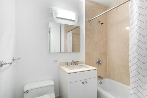 a bathroom with a sink and a toilet and a shower at Midtown 2BR w Pool Gym Roof nr Broadway NYC-382 in New York