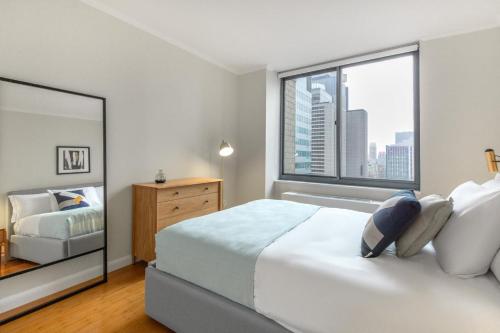 a bedroom with a large bed and a window at Midtown 2BR w Pool Gym Roof nr Broadway NYC-382 in New York