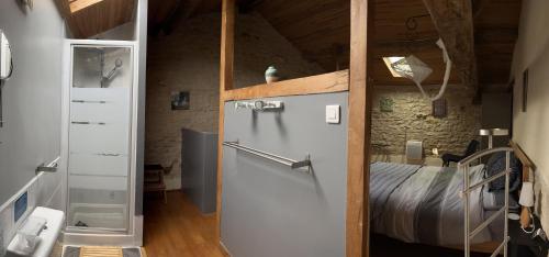Zimmer mit einem Kühlschrank und einem Bett. in der Unterkunft Gites Le Bois de l'Eglise in Villiers-le-Roux