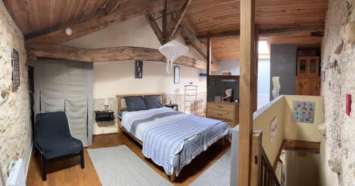 ein Schlafzimmer mit einem Bett und einem Stuhl darin in der Unterkunft Gites Le Bois de l'Eglise in Villiers-le-Roux