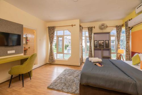 a bedroom with a bed and a desk and a television at Zostel Srinagar in Srinagar