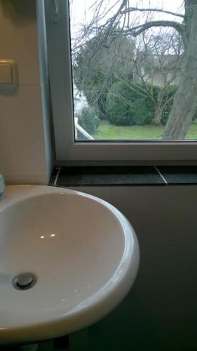 a white sink in a bathroom with a window at Toll Apartment mit privatem Eingang free Parking Slbst Check-in 30 Zone ruhig keine Ferienwohnung in Duisburg