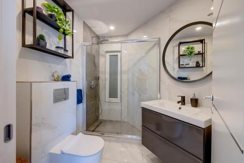 La salle de bains est pourvue d'une douche, de toilettes et d'un lavabo. dans l'établissement Modern 1BR Apartment Central Location, à Il-Gżira