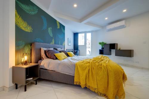 Un dormitorio con una cama con una manta amarilla. en Modern 1BR Apartment Central Location, en Il-Gżira