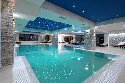 una piscina en una casa con techo azul en Magnolija Resort Ponikva, en Kočani