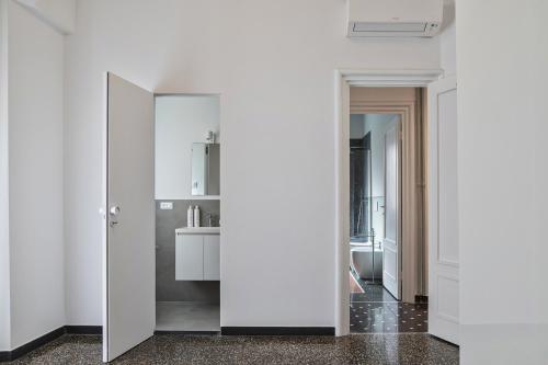 a hallway with white walls and a mirror at Beauty & Design in the Center by Wonderful Italy in Genova