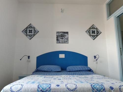 een bed met een blauw hoofdeinde in een slaapkamer bij La Rosa di Orvieto in Orvieto